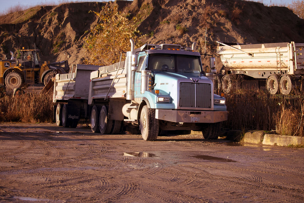 Hughes Trucking equipment and hauling services on site.